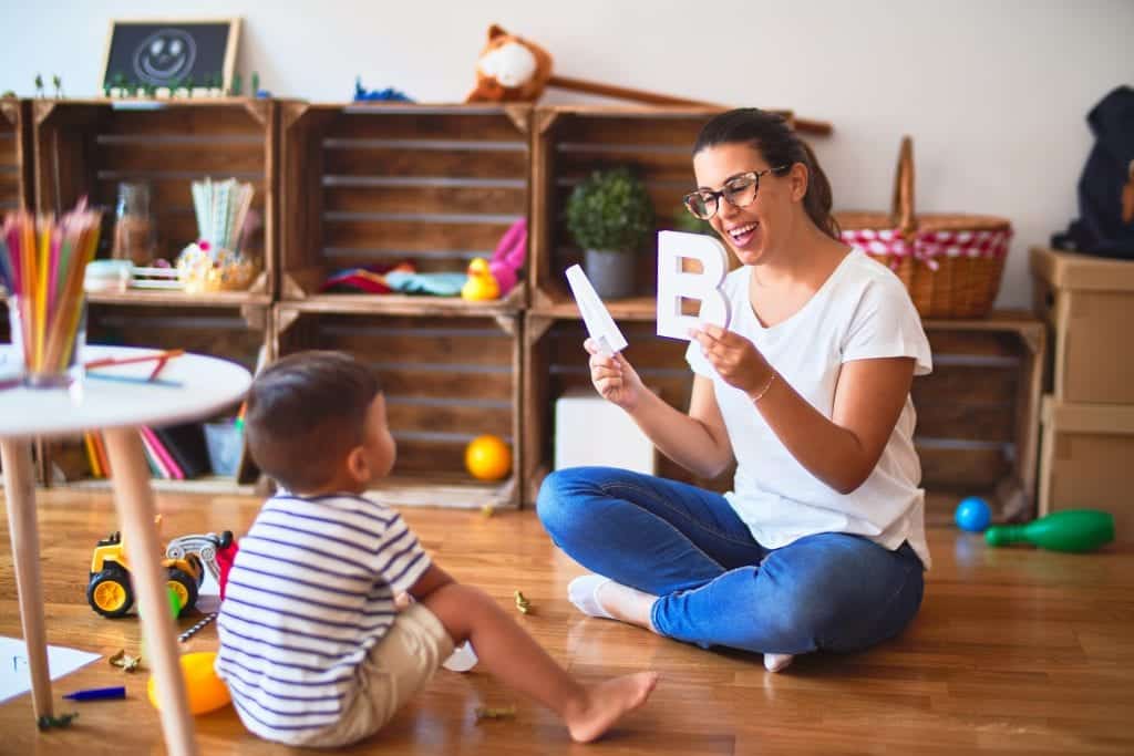 Behaviour Therapist showing a child big block letters in a play room during an ABA therapy in Toronto
session.