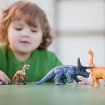 Child with autism playing with dinosaurs. 